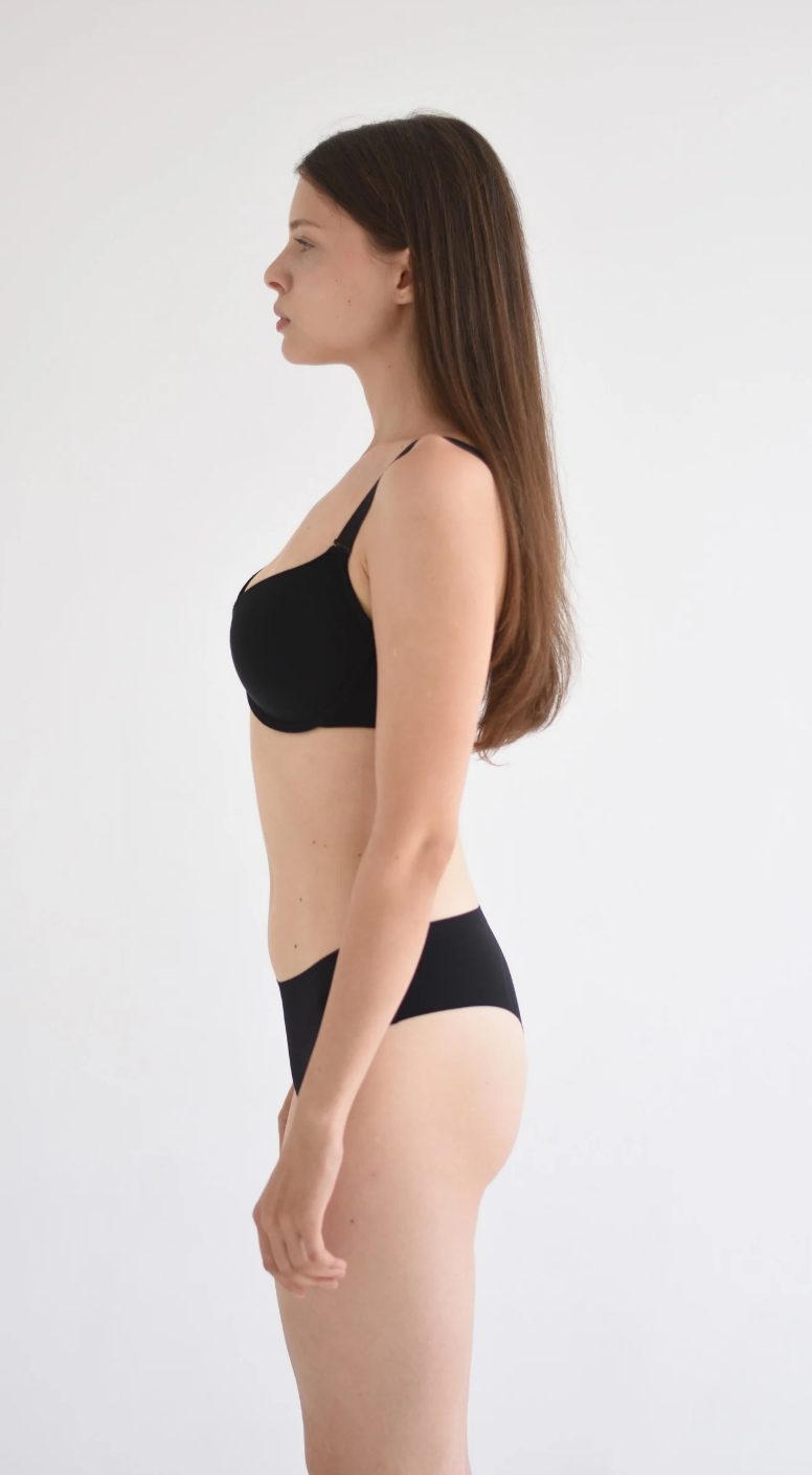 Half-body digital of a female model, side view, plain background
