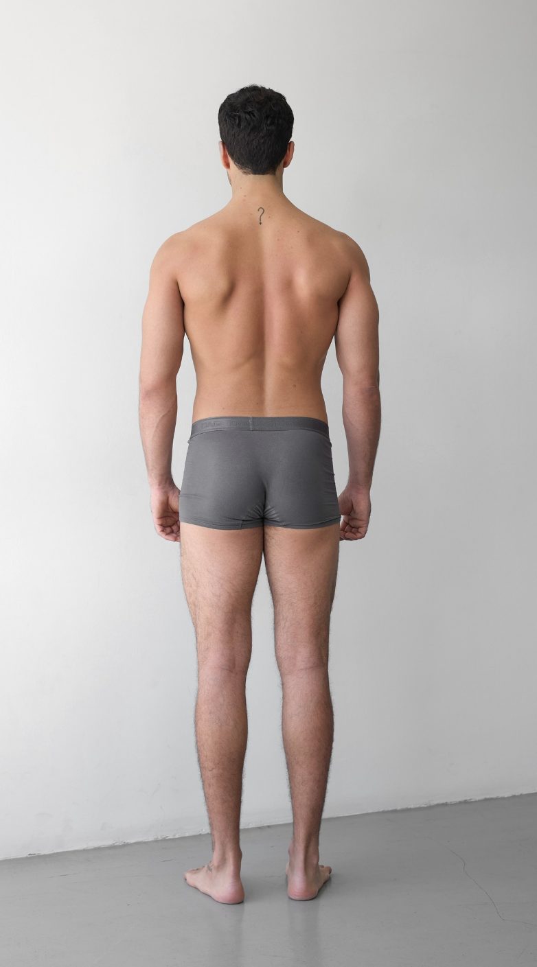 Digital en pied d’un mannequin homme, vue de dos, devant un mur uni